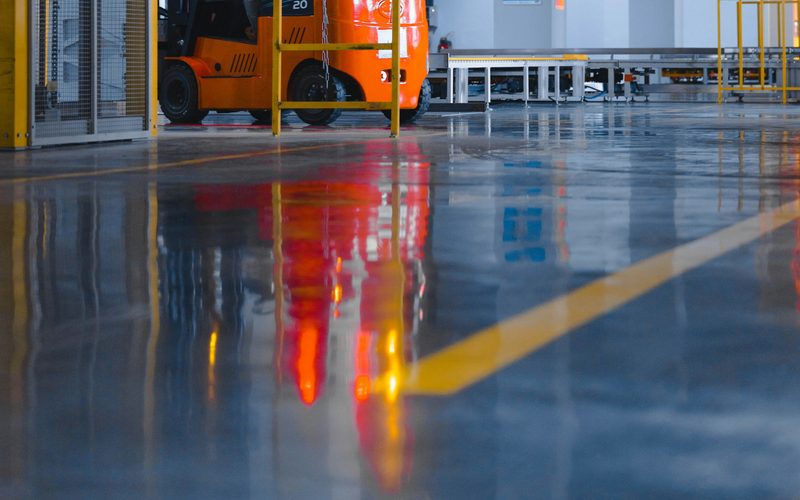 Ligne de marquage au sol et chariot élévateur dans un hall industriel
